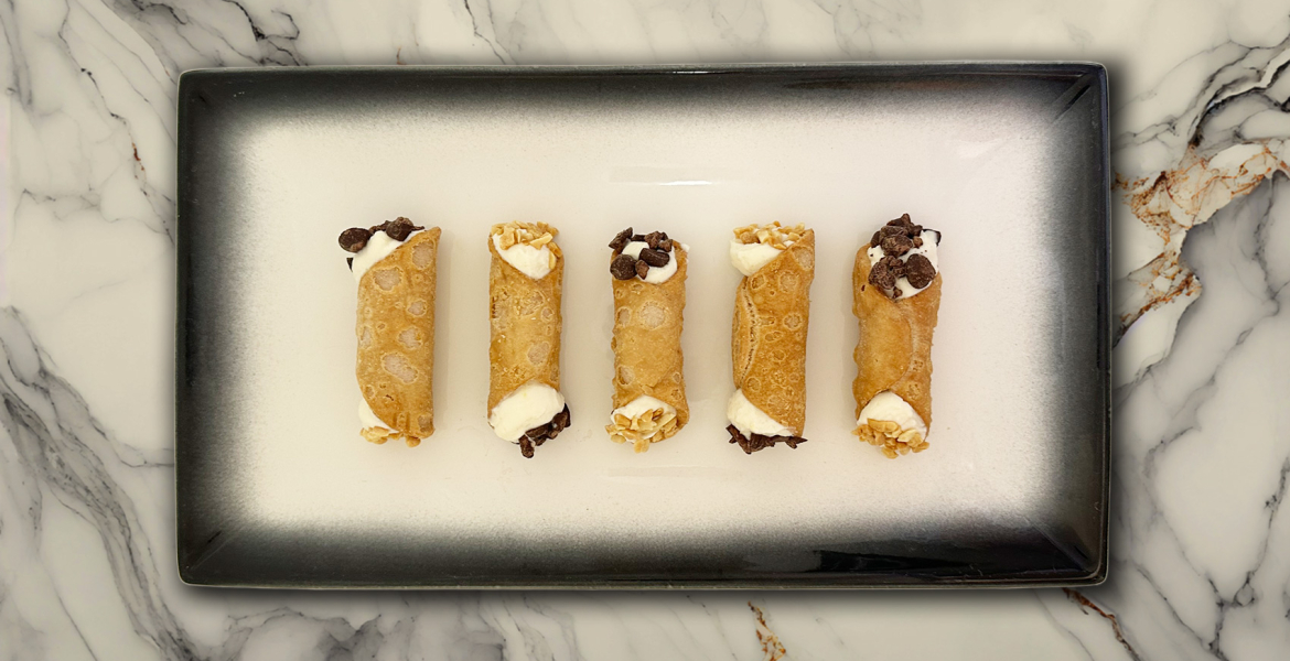Cannoli filled with custard & dipped in choc + peanuts